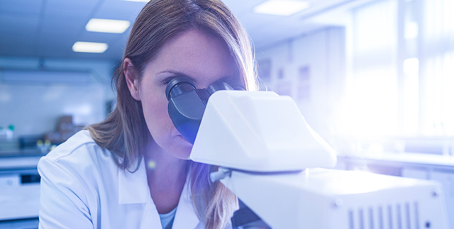 Scientist working with a microscope in laboratory